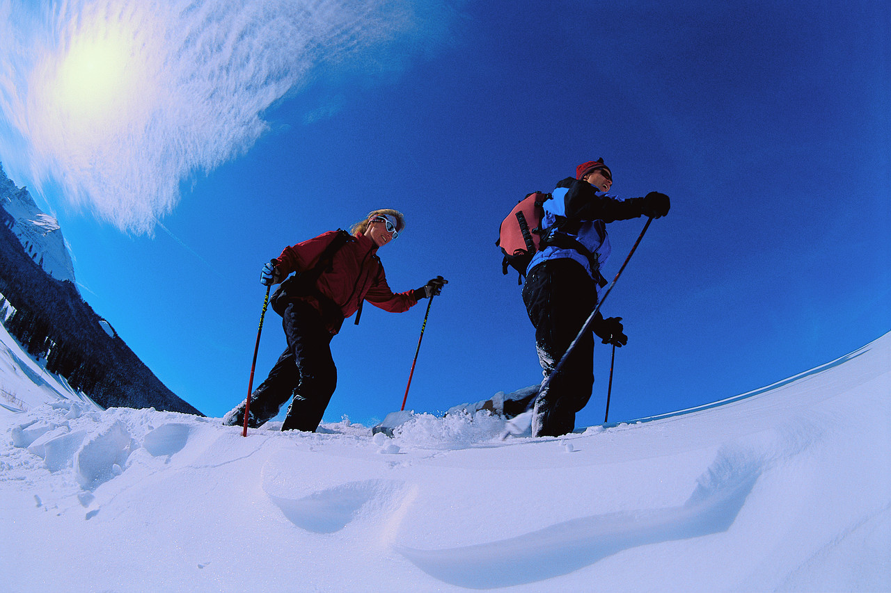 MP9003999211 Couple Snowshoeing Across Landscape